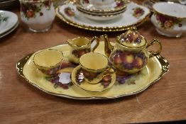 A miniature tea set, having fruit pattern with gilt edging.