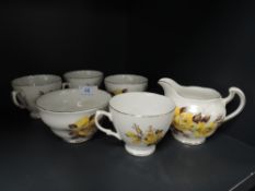 A small collection of bone china having yellow rose pattern and gilt edging , includes sugar