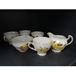 A small collection of bone china having yellow rose pattern and gilt edging , includes sugar