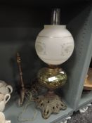 A Victorian oil burning lamp having cast base, yellow pressed glass well and heavy etched shade