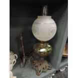 A Victorian oil burning lamp having cast base, yellow pressed glass well and heavy etched shade