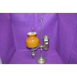 An antique desk top or students oil lamp, having Ochre glass shade and internal chimney.