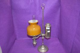 An antique desk top or students oil lamp, having Ochre glass shade and internal chimney.