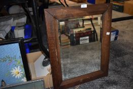 An oak framed and bevel edged mirror