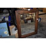 An oak framed and bevel edged mirror