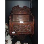 An arts and crafts style oak smokers cupboard and pipe rack having carved floral work and dated