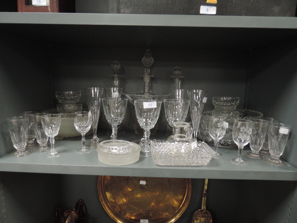 A selection of clear cut and crystal glass wares including decanters and champagne flutes