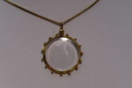 A glass locket in a decorative 9ct gold mount on a 9ct gold box chain, approx 17'