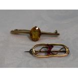 A small 9ct gold brooch of open oval form having central rubies, and a yellow metal bar brooch