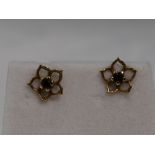 A pair of 9ct gold stud earrings having sapphire chips in open petal surrounds, approx 1g