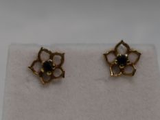 A pair of 9ct gold stud earrings having sapphire chips in open petal surrounds, approx 1g