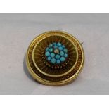 A Victorian yellow metal brooch having a turquoise and seed pearl set cluster centre within a