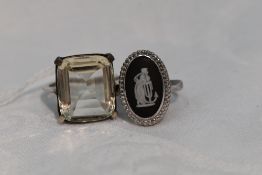 A lady's dress ring having an oversized paste stone to four claw collared mount to white metal loop,