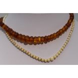 A string of facetted Baltic amber graduated beads and a string of graduated cultured pearls