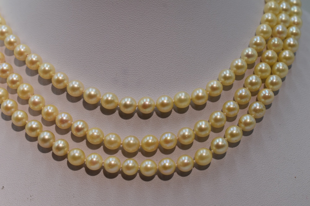 A mid 20th Century triple row cultured pearl necklace, each pearl of even form having decorative