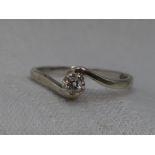 A lady's diamond solitaire dress ring, approx 0.1ct in a raised claw mount to crossover shoulders on