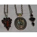 Three silver pendants of Artisan style having garnet, coral and green/red paste stone decoration