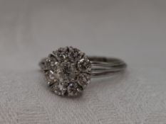 A lady's dress ring having a diamond cluster, total approx 1ct in a raised claw set basket mount