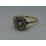 A lady's dress ring having a diamond star burst cluster, approx 0.5ct on a yellow metal loop, no