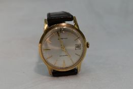 A gents 1970's yellow metal automatic wrist watch by Garrard having a baton numeral dial with date