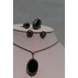 A three piece set of hematite jewellery including pendant ring and earrings in white metal mounts