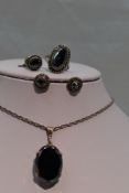 A three piece set of hematite jewellery including pendant ring and earrings in white metal mounts