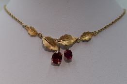 A yellow metal necklace stamped Vanuell 14K having a pair of oval rubies in claw set drops from