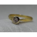 A lady's diamond solitaire dress ring, approx 0.25ct in a collared mount on an 18ct gold loop,