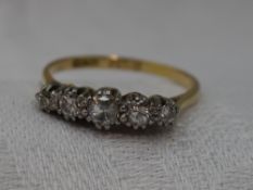 A lady's dress ring having five graduated diamonds in a claw set raised mount on a yellow metal loop