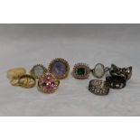 A selection of fashion rings of various designs including cherub, moonface, faux opal etc, some