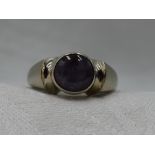 A lady's dress ring of Artisan form having a star sapphire cabochon in a collared mount to shaped