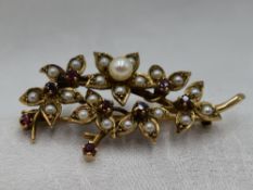 A 9ct gold brooch modelled as a bunch of flowers having cultured and seed pearl and ruby decoration