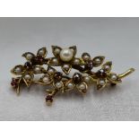 A 9ct gold brooch modelled as a bunch of flowers having cultured and seed pearl and ruby decoration