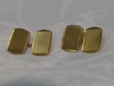 A pair of 9ct gold cufflinks having engine turned decoration, plain panels and chain connecters