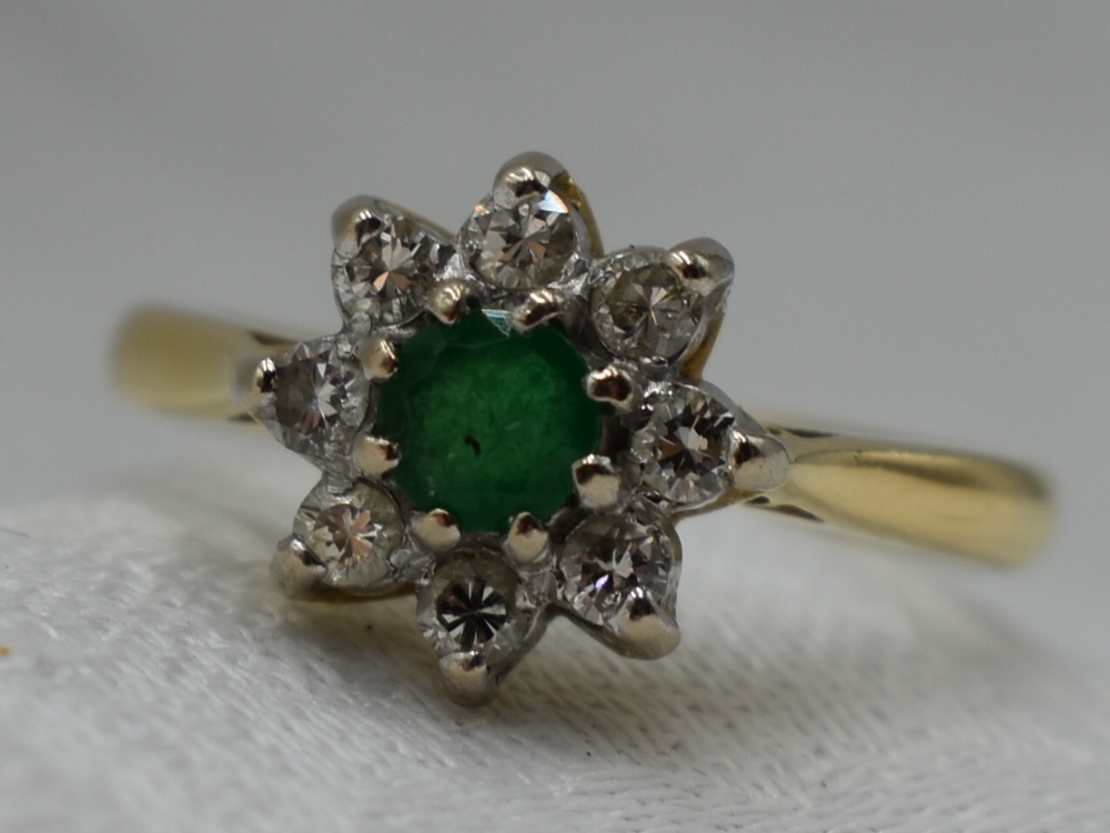 A lady's dress ring having an emerald and diamond cluster in a claw set mount on an 18ct gold - Image 2 of 8