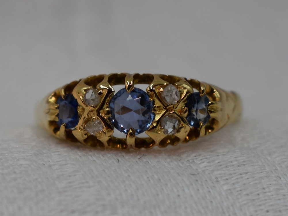 A lady's dress ring having three graduated powder blue sapphires interspersed by four small diamonds