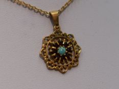 A 9ct gold pendant having turquoise and red paste decoration in a pierced mount on a 9ct gold chain