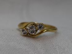 A lady's dress ring having a trio of clear stones, possibly white sapphires, in a claw set mount
