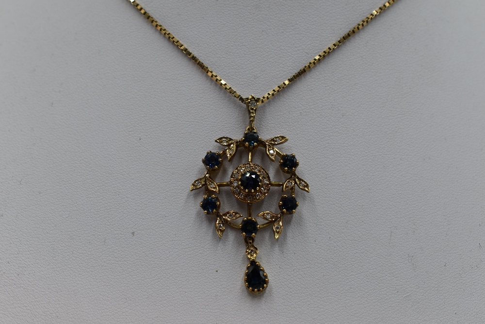 An Edwardian style 9ct gold pendant having central sapphire and diamond cluster in a diamond and