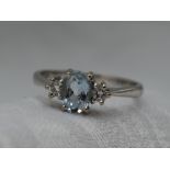 A lady's dress ring having a central aqua marine flanked by two diamonds in a claw set collared