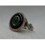 A lady's dress ring having a central emerald cabouchon in a black onyx oval mount with diamond