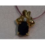 An iolite and diamond pendant in a moulded 9ct gold mount