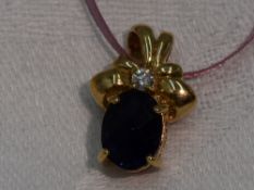 An iolite and diamond pendant in a moulded 9ct gold mount