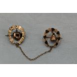 A Victorian 9ct gold horse shoe brooch duo with suspended heart and bell charms and chain connecter
