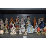A shelf full of figurines, Including IVO and staffordshire style pieces.