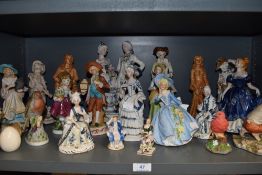 A shelf full of figurines, Including IVO and staffordshire style pieces.