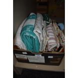 A box full of vintage table linen, embroidered table cloths, aprons, towels and more.