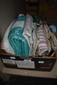A box full of vintage table linen, embroidered table cloths, aprons, towels and more.