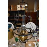 A large vintage brass oil or paraffin lamp with a cast metal ceiling mount.