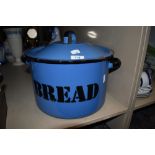 A vintage blue enamel bread bin having black lettering.